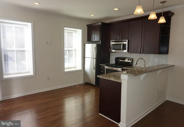 a kitchen with wooden cabinets and stainless steel appliances