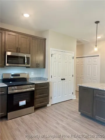 a kitchen with stainless steel appliances granite countertop a stove a sink and a refrigerator