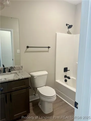 an empty room with wooden floor ceiling fan and windows