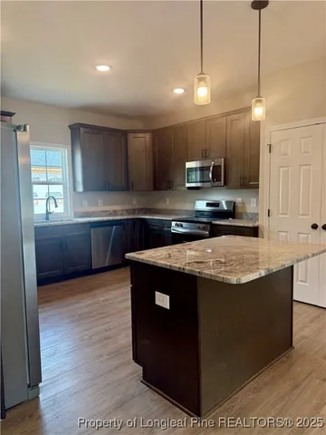 a kitchen with stainless steel appliances granite countertop a refrigerator a sink and a oven