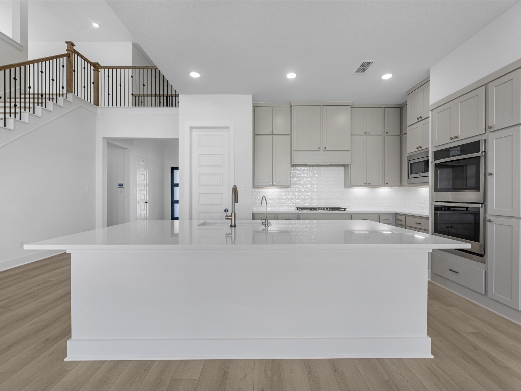 8011 Sunny Rdg Drive Fulshear, TX 77441 - Photo 2 of 32 a large white kitchen with kitchen island white cabinets and stainless steel appliances