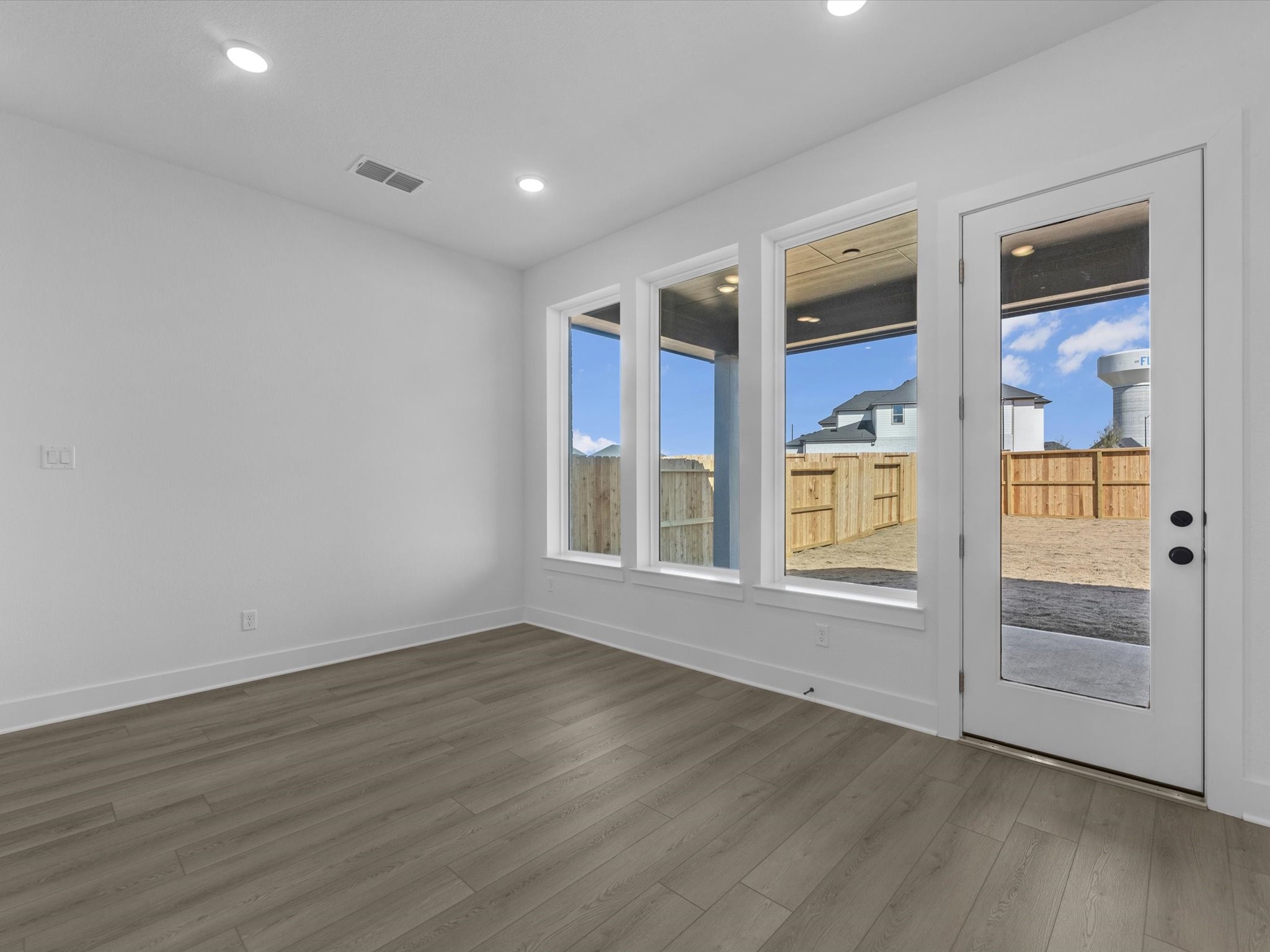 8011 Sunny Rdg Drive Fulshear, TX 77441 - Photo 5 of 32 an empty room with wooden floor and windows