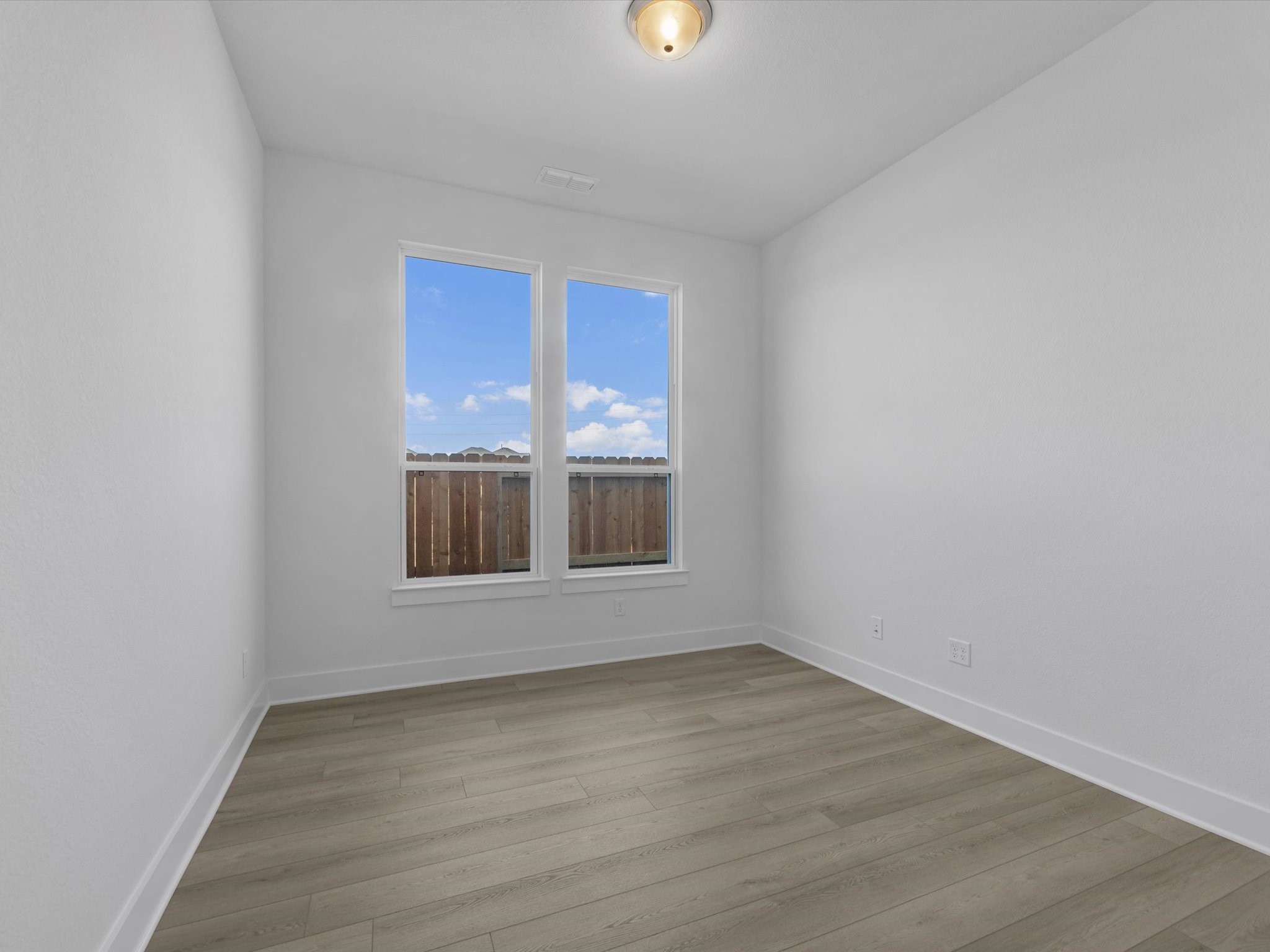8011 Sunny Rdg Drive Fulshear, TX 77441 - Photo 6 of 32 a view of an empty room with wooden floor and a window
