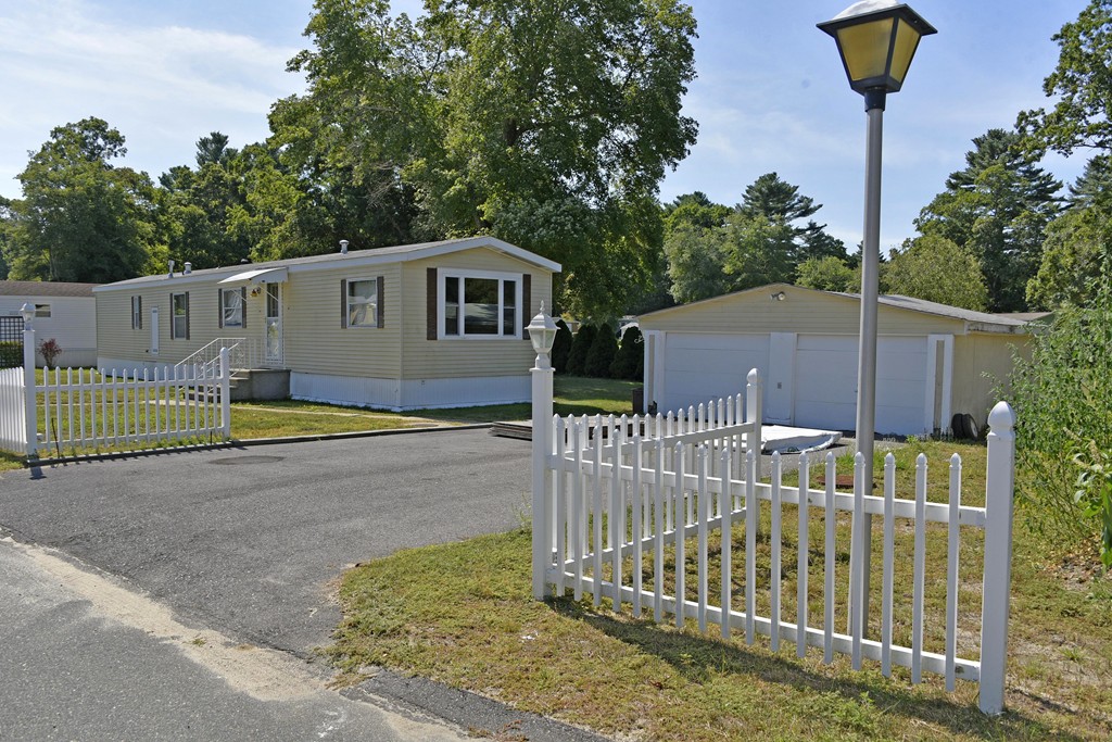 a view of a house with a small yard and wooden fence