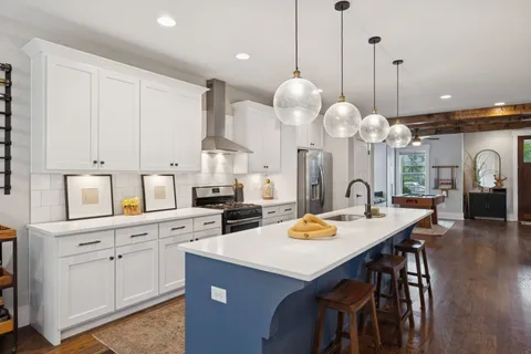 a kitchen that has a lot of cabinets and a wooden floor