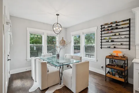 a dining room with furniture large windows and wooden floor