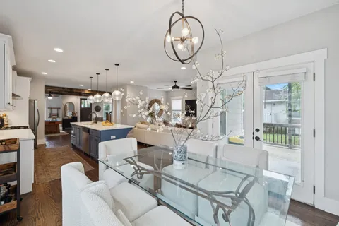 a dining room with wooden floor a glass table and chairs