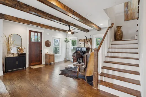 a view of a hallway with wooden floor and furniture