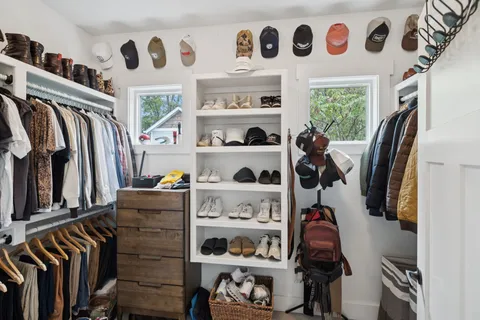a view of walk in closet with clothes and shoes