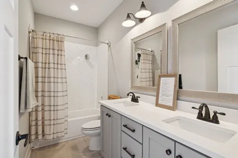 a bathroom with a double vanity sink toilet and shower