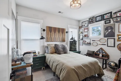 a bedroom with a bed and a dresser with rug