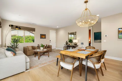 a view of a dining room with furniture a chandelier and wooden floor