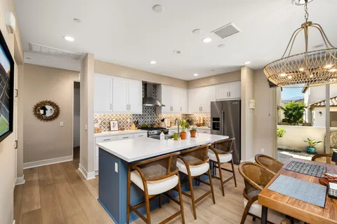 a kitchen with a dining table chairs refrigerator and cabinets