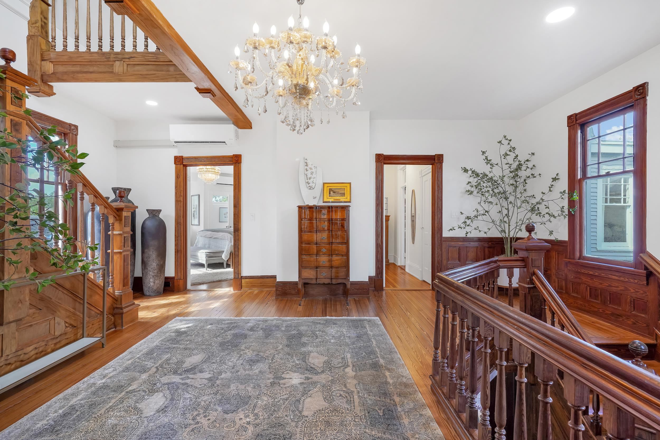 268 St George Street St. Augustine, FL 32084 - Photo 23 of 71 Hallway featuring stairway, wood finished floors, a chandelier, recessed lighting, and an AC wall unit