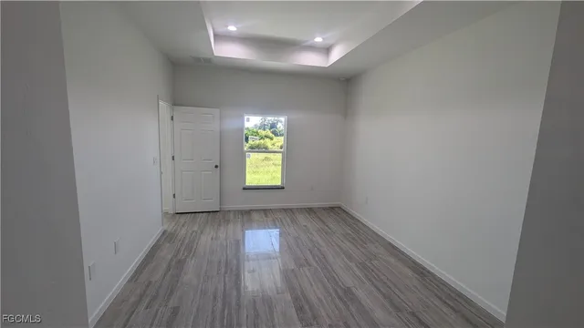 a view of an empty room with wooden floor