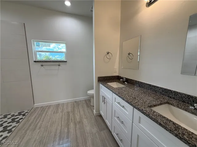 a view of an empty room and wooden floor and a window