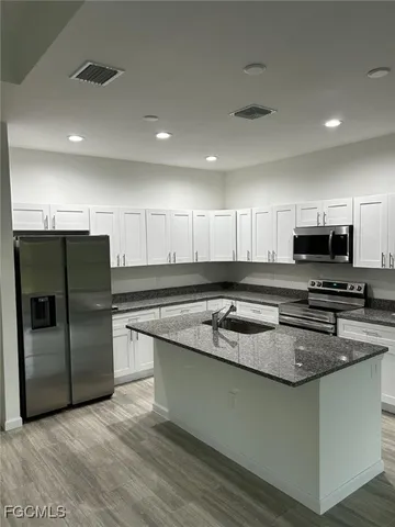 a kitchen with stainless steel appliances granite countertop a stove a sink and a refrigerator