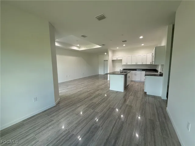 a kitchen with a refrigerator and white cabinets