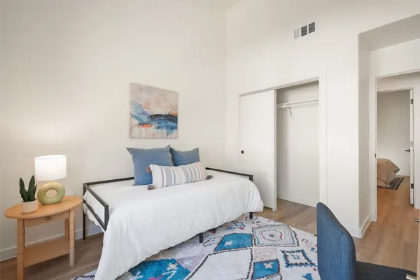 a bedroom with a bed and wooden floor