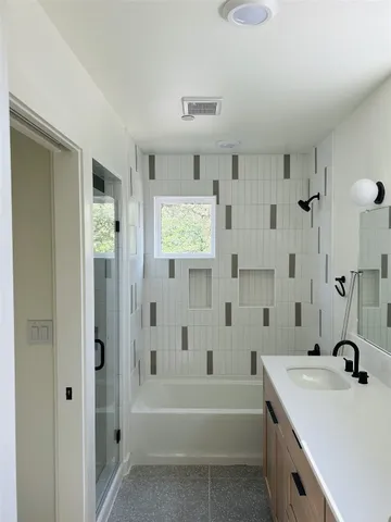 a bathroom with a tub sink and mirror