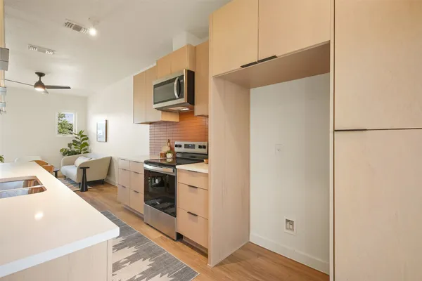 a kitchen with stainless steel appliances a stove a sink and a refrigerator