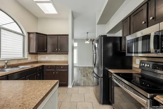 a kitchen with stainless steel appliances granite countertop a refrigerator and a sink