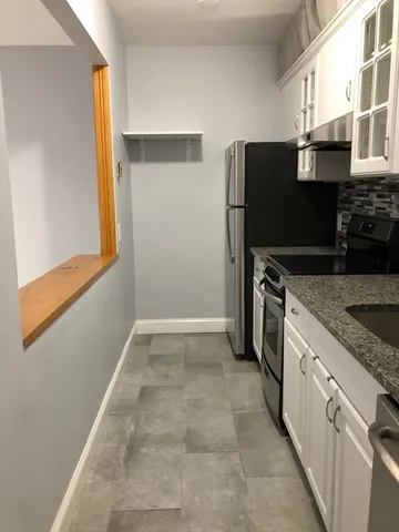 a kitchen with stainless steel appliances granite countertop a refrigerator and a stove