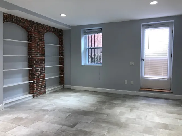a view of an empty room with a fireplace and a window