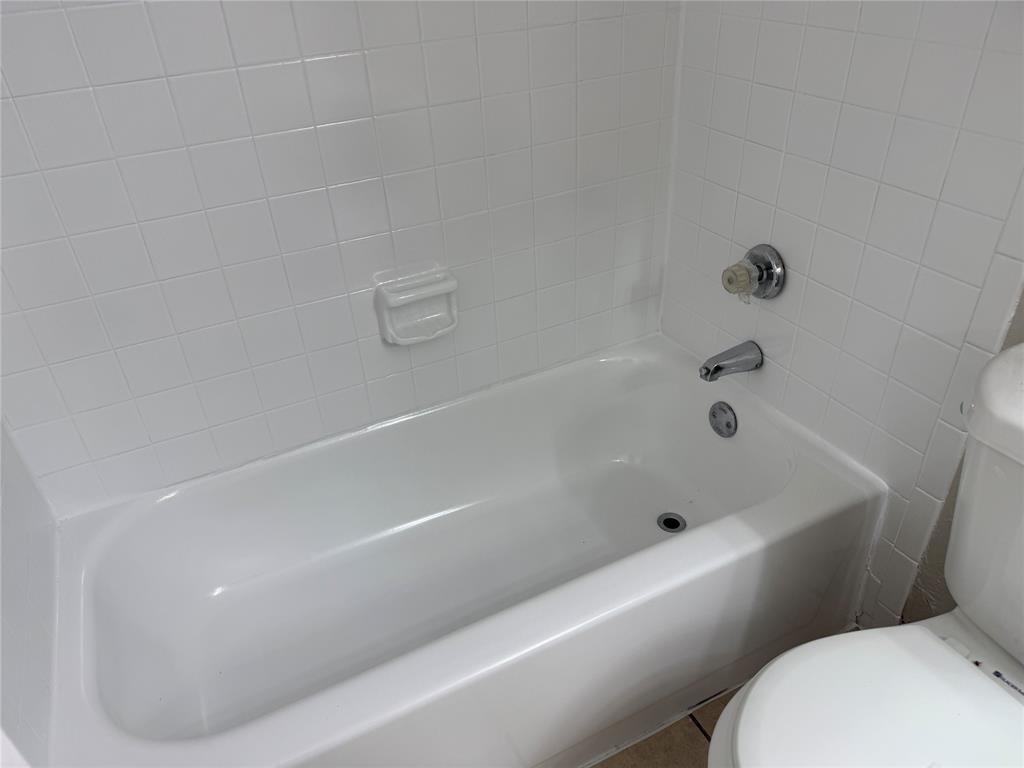 9520 Royal Lane, Unit 214 Dallas, TX 75243 - Photo 11 of 13 a bathroom with a bathtub and toilet