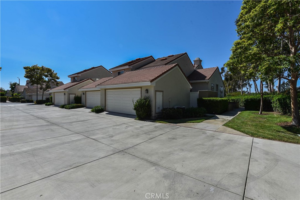 55 Wellesley, Unit 55 Irvine, CA 92612 - Photo 8 of 11 a front view of a house with a yard and a garage