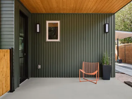 a backyard of a house with chairs