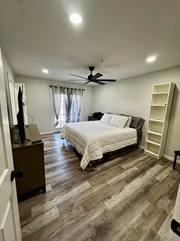 a bedroom with a bed and wooden floor
