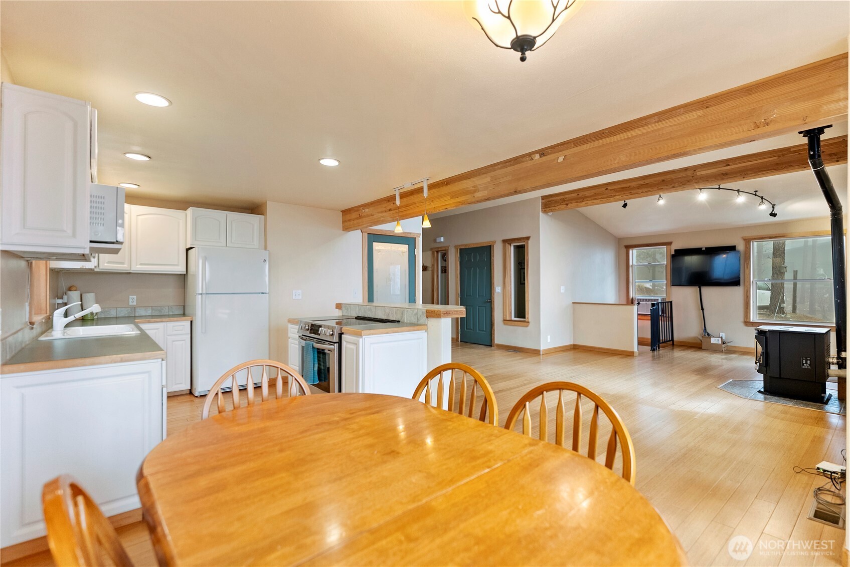 80 Homestead Road Winthrop, WA 98862 - Photo 19 of 40 a large kitchen with stainless steel appliances granite countertop a sink a stove a dining table and chairs with wooden floor