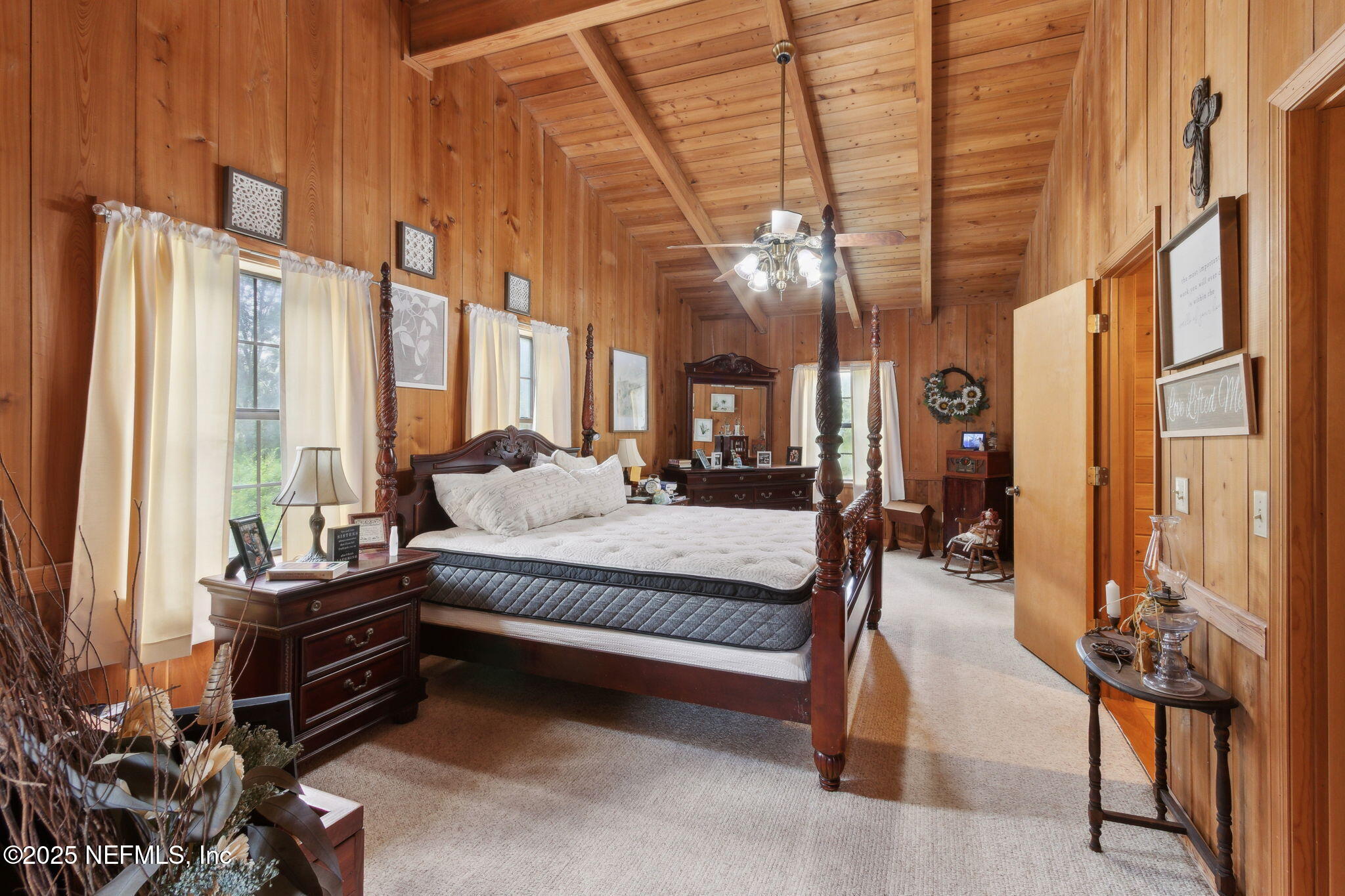 37334 Alice Street Hilliard, FL 32046 - Photo 29 of 80 a spacious bedroom with a bed a chandelier and large windows