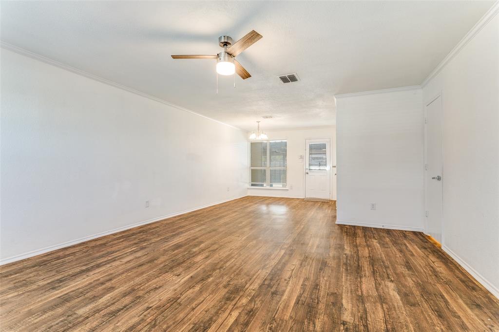 5616 Giddyup Lane Fort Worth, TX 76179 - Photo 7 of 28 Unfurnished room with a chandelier, dark wood-type flooring, ornamental molding, and ceiling fan