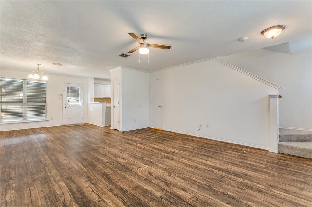 5616 Giddyup Lane Fort Worth, TX 76179 - Photo 8 of 28 Unfurnished living room with stairway, a chandelier, dark wood-style flooring, and ceiling fan