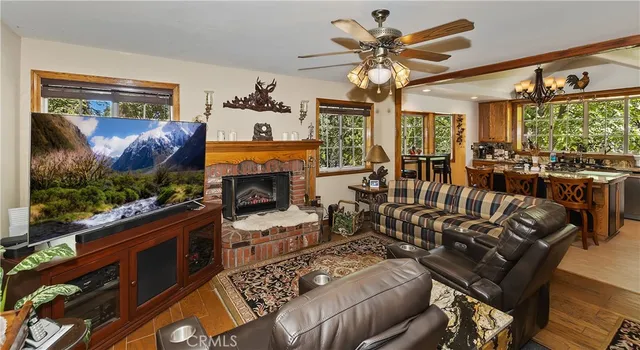 a living room with furniture a flat screen tv and a floor to ceiling window