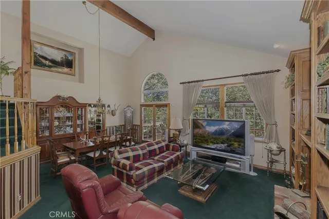 a living room with furniture a flat screen tv and a floor to ceiling window