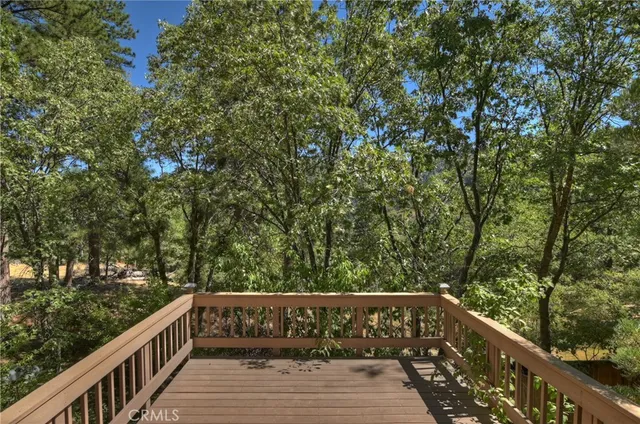 a view of balcony with wooden floor and trees