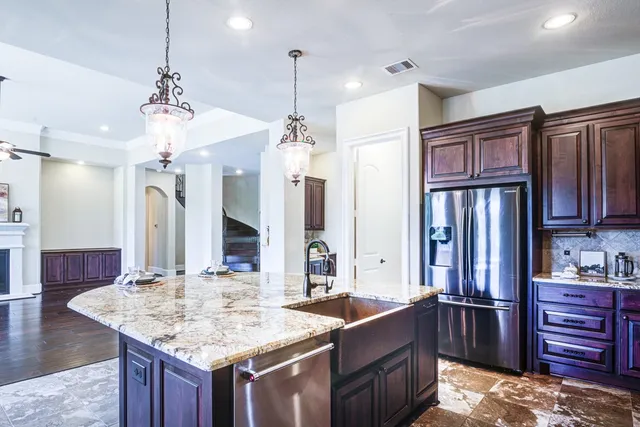 a kitchen with stainless steel appliances granite countertop a sink stove and refrigerator