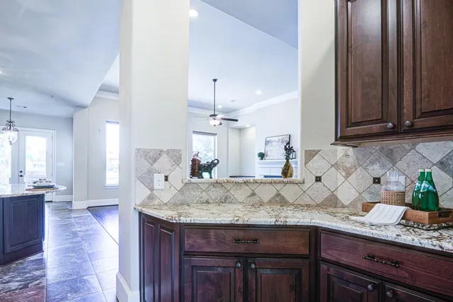 a kitchen with granite countertop kitchen island sink table and chairs