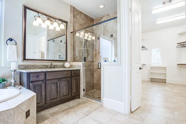 a bathroom with a granite countertop sink mirror and a shower