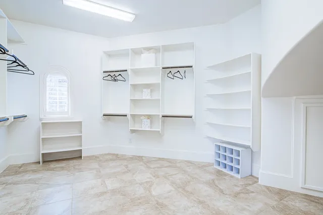 a view of walk in closet with empty racks