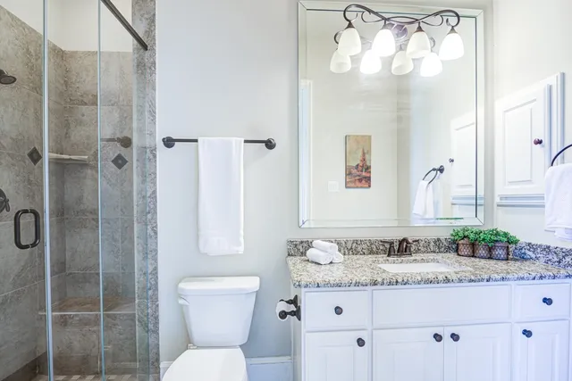 a bathroom with a granite countertop sink toilet and shower