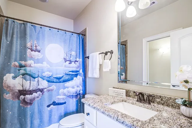 a bathroom with a sink vanity mirror and toilet