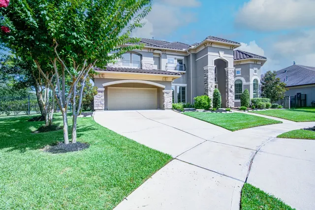 a front view of a house with a garden and yard