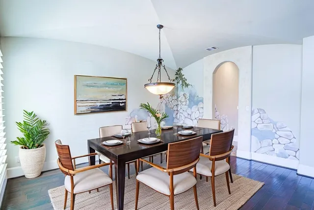 a dining room with furniture potted plants and wooden floor