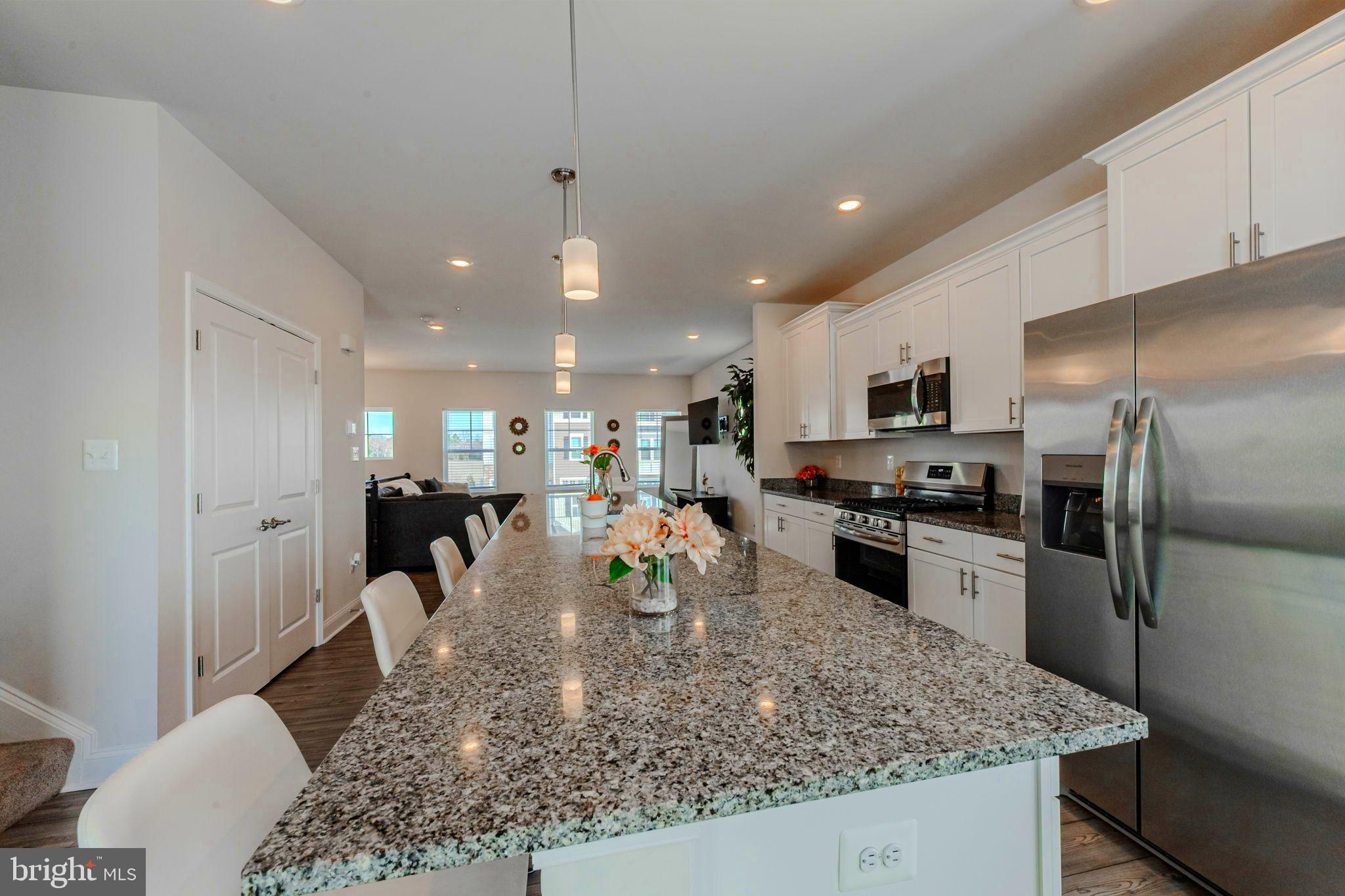 35262 Wright Way Millsboro, DE 19966 - Photo 8 of 42 a kitchen with a refrigerator a stove top oven a sink and living room view