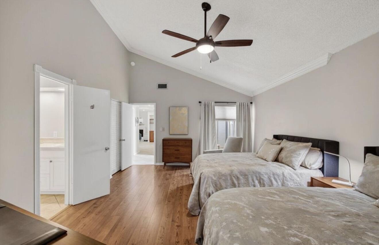 7745 Stanway Place Boca Raton, FL 33433 - Photo 3 of 7 a bedroom with a large bed and a chandelier