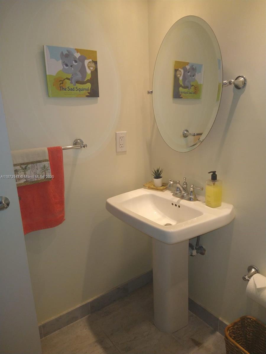 9341 Collins Avenue, Unit 806 Surfside, FL 33154 - Photo 11 of 27 a sink and a mirror
